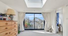 an empty bedroom with a skylight above the bed and large windows on the wall