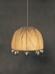 a lamp hanging from a ceiling with three balls on it's end and one light in the middle