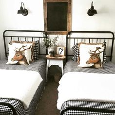 two twin beds with black and white checkered covers in a room that has a chalkboard on the wall