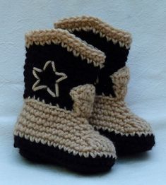 a pair of crocheted black and tan boots with a star on the side