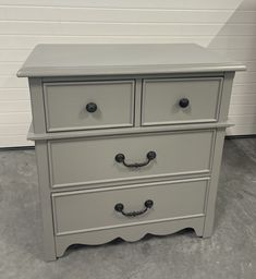 a gray dresser with two drawers and handles