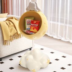 a white cloud shaped object on top of a table next to a couch and window