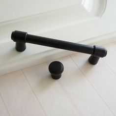 a black handle on the side of a white sink