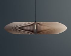 a wooden light fixture hanging from a ceiling in a dark room with grey walls and flooring