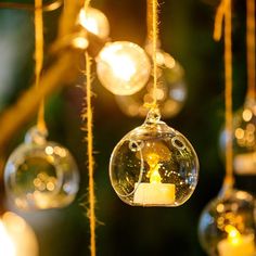 an ornament hanging from a tree filled with bubbles and candles in front of a christmas tree