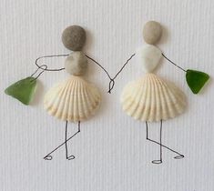 two people are holding hands and standing next to each other with seashells on their backs