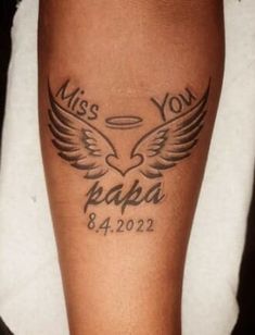 a man with a tattoo on his leg that reads miss you papa and has wings