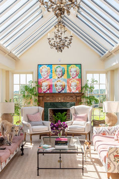 a living room filled with lots of furniture and a painting on the wall above it