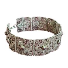 "Silver Filigree Bracelet, Vintage, Art Deco, Hinged Panel, Swirled Wire Bracelet, Very Feminine, Unmarked, Antique, 7\" Long, 13 Grams This beautiful vintage filigree bracelet features intricate floral details swirling around cross and bead details Nine hinged panel links, with lace-like appearance Each panel link is 5/8\" square Hook and loop closure Very feminine! Unmarked, but believed to be sterling or 800 coin silver filigree; magnet does not stick to bracelet Weights 13 grams Approximate measures: 7\" L x 5/8\" W Condition consistent with vintage age; minor wear on a few panels Detailed cleaning is left up to purchaser, if desired Please use pictures as an inclusive part of the description Smoke and pet free home Silver Filigree Hinged Panel Bracelet Art Deco Design" Luxury Traditional Filigree Bracelet, Bracelet Art, Filigree Bracelet, Beautiful Handbags, Bracelet Vintage, Wire Bracelet, Silver Filigree, Jewelry Tutorials, Vintage Art Deco