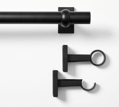 two black metal handles on a white wall