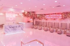 the interior of a nail salon with pink lighting