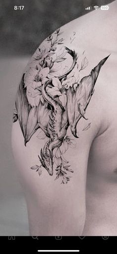 the back of a man's shoulder with flowers on it and an image of a dragon