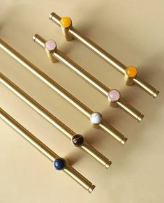 four different colored knobs on the handles of some metal bars and poles, all in various shapes and sizes