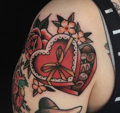 a close up of a woman's shoulder with tattoos on her arm and chest