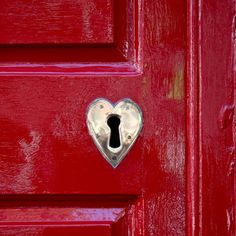 a red door with a heart shaped keyhole