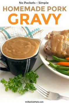 a white plate topped with meat covered in gravy next to green beans and carrots