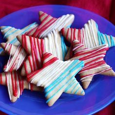 red, white and blue striped cookies on a blue plate in the shape of stars