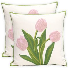 two pink tulips embroidered on white pillows with green piping around the edges