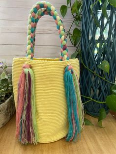 Description:  Cute Pastel Green & Pink Top Handle Bag These Boho bag was 100% hand knit by Wayuu Women but designed by us. The Wayuu are an indigenous tribe in Colombia known for their beautiful handwoven work, and this bag represents about a week's worth of work. Details: Handmade item - Handwoven Color: Yellow, Pink, Green, & Blue  Material: 100% Acrylic Width: 11" Height: 11" Total Length: 20" Materials: Nylon, Cotton Style: Boho Chic/ Flirty/ Kawaii/ Hippie Chic/ Trendy Check out other simil Cute Rectangular Bucket Bag For Everyday Use, Playful Bucket Bag For Everyday Use, Cute Rectangular Beach Bag For Everyday Use, Cute Multicolor Bags For Daily Use, Cute Multicolor Rectangular Shoulder Bag, Cute Multicolor Daily Use Bags, Cute Rectangular Natural Color Bag, Cute Natural Rectangular Bags, Multicolor Bucket Bag With Braided Handles For Daily Use