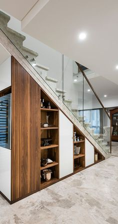 an open staircase leading up to a living room with glass balconies and wooden shelves