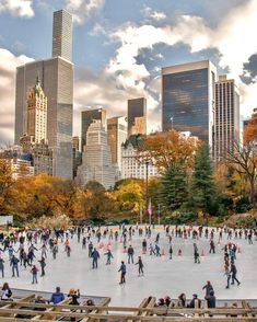 many people are skating on an ice rink in the middle of a city with tall buildings