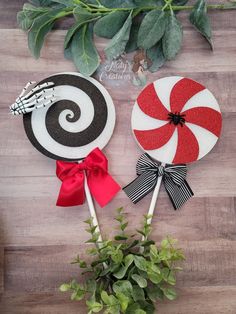 two candy lollipops sitting on top of a wooden table next to a potted plant