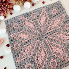 someone is crocheting an afghan on the table with flowers and eggs around it