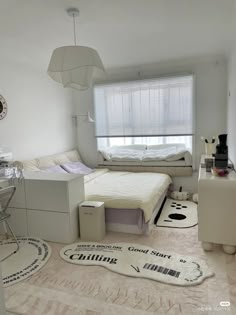 a bedroom with a bed, desk, and window in the corner on the floor