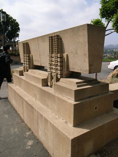 a cement sculpture sitting on the side of a road