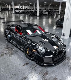 a black and red sports car parked in a parking garage