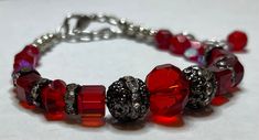 Beautiful red crystal glass beads paired up with metal beads with rhinestones  Measures 7.25" long with a 2" extension. Will be sent to you in a gift box. Strings are reenforced with end enforcers for less chance of breaking from wear. Silver Beaded Crystal Bracelet For Valentine's Day, Valentine's Day Silver Beaded Crystal Bracelet, Red Metal Crystal Bracelet Gift, Red Crystal Bracelet Gift, Red Crystal Bracelet For Gift, Crystal Bracelets As Valentine's Day Gift, Crystal Bracelets For Valentine's Day Gift, Elegant Red Crystal Bracelet, Adjustable Red Crystal Bracelet