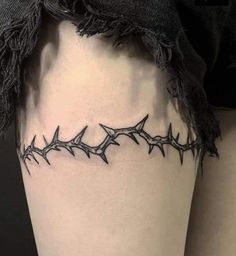 a woman's thigh with barbed wire tattoo on her leg and the bottom part of her thighs