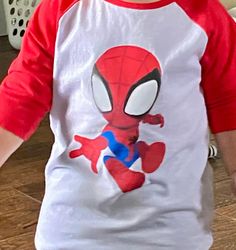 Red & White Toddler Baseball Shirt with Spidey on front and web on back. This cute baseball t-shirt features a white center with bright red half sleeves and collar.   100% Cotton Machine wash warm; tumble dry low; non-chlorine bleach when needed.  Iron inside out if needed. Sporty Red T-shirt With Raglan Sleeves, Playful Red Character Print T-shirt, White Pre-shrunk Short Sleeve Baseball Jersey, Red Short Sleeve Baseball Jersey With Letter Print, White Sporty Top With Character Print, Sporty White Top With Character Print, White Cotton Baseball Jersey With Short Sleeves, White Cotton Short Sleeve Baseball Jersey, Red Cotton Baseball Jersey For Baseball Season