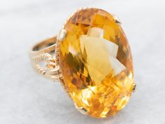 "Sleek styling and modern features, this smooth yellow gold ring is sure to impress. This ring features clean lines and nice proportions, and the yellow gold really accents the stunning golden yellow oval cut citrine dazzling in the center. The rope detail on the band adds uniqueness without taking away from the citrine gemstone. Metal: 14K Yellow Gold Gem: Citrine totaling 25.30 Carats Gem Measurements: 24.6 x 16.2 mm, Oval Ring Size: 6.5 Marks: \"14K\" Stamped on the inside band To view a video of this piece check out the link below: https://vimeo.com/799616497 SKU: A20631 Each piece has been identified and graded by a Graduate Gemologist who has been certified by the Gemological Institute of America (GIA). We have five brick and mortar storefronts in Maine, Massachusetts and New Hampshi Right Hand Ring, Right Hand Rings, Hand Ring, Citrine Ring, Oval Rings, November Birthstone, Citrine Gemstone, Vintage Love, Golden Yellow