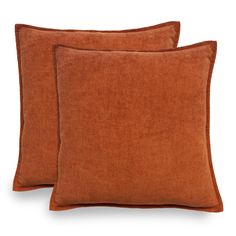 two orange pillows sitting next to each other