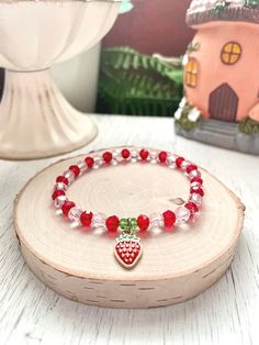 Pink and Red Strawberry Stretch Bracelet - Cottage Core Jewelry  Strawberries remind me of summer. But you can wear this all year round!  This beaded stretch bracelet fits perfectly into the cottage core and coquette aesthetics.   It appeals to so many people!   I think it will be LOVED by anyone who adores: strawberries,  strawberry themed bracelets or strawberry jewelry,  cottage core jewelry,  cottage core bracelets,  coquette bracelets,  coquette jewelry,  girly bracelets,  berry bracelets,  fans of the vintage berry girl with a delicious sounding name...  Pink and red glass crystal beads on strong stretch cord with green crystal beads.  An enamel strawberry charm is attached with a stainless steel jump ring to make the cutest strawberry bracelet! You will receive the item pictured.  A Bracelets Coquette, Coquette Bracelets, Strawberry Bracelet, Cottage Core Jewelry, Strawberry Jewelry, Themed Bracelets, Coquette Jewelry, Girly Bracelets, Strawberry Charm