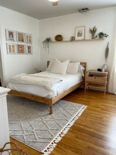 a bed sitting on top of a wooden floor in a bedroom