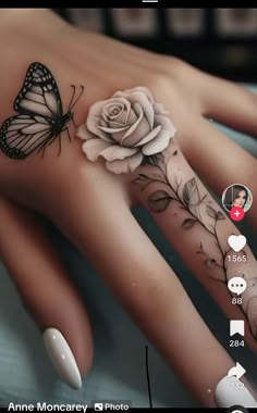 a woman's hand with a butterfly and rose tattoo on it