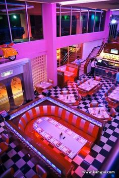 the inside of a restaurant with checkered flooring and neon lights on the walls