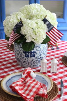 a red and white checkered table cloth with an american flag centerpiece on it