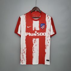 a red and white soccer jersey hanging on a hanger