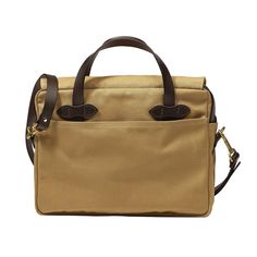 a tan canvas bag with two brown leather handles on the front and one black handle on the back