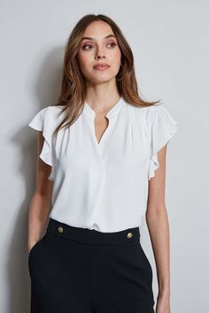 The soft cap sleeves lend a femme twist to this luxe georgette top. With its contour pleat detail neckline, it is perfect for layering with your favorite blazer or wearing on its own. T-Tahari Short Sleeve V-Neck Top Runs true to size. Model is 5'9" and wearing size S Dry Clean Only Imported Style #: THF44013 Elegant Short Sleeve Tops For Office Wear, Chic Formal Tops With Ruffle Sleeves, Elegant Flutter Sleeve Blouse For Work, Elegant Fitted Tops With Cap Sleeves, Elegant Ruffle Sleeve Tops For Office, Chic Flutter Sleeve Blouse For Work, Elegant Ruffle Sleeve Blouse For Work, Chic Workwear Blouse With Flutter Sleeves, Chic Fitted Cap Sleeve Tops