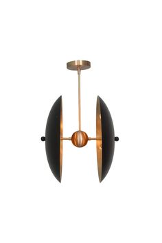 a brass and black pendant light with two circular lights hanging from it's sides