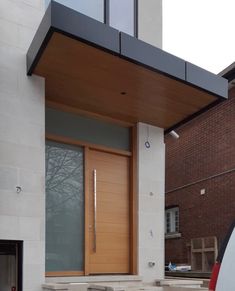 a car parked in front of a building with a wooden door and window frame on the side