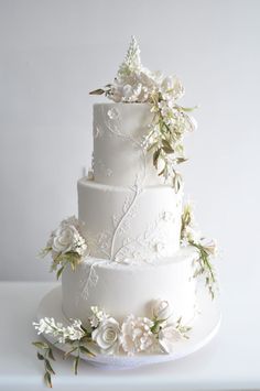 a wedding cake with white flowers and greenery