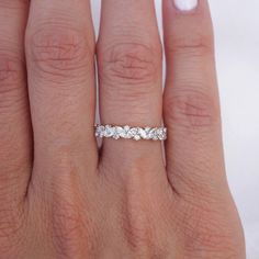 a woman's hand with a wedding band on it and a diamond ring in the middle