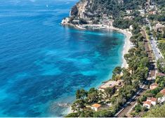 an aerial view of a beach and the ocean with houses on it's sides