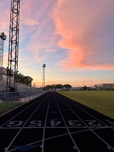 the sun is setting over an empty track