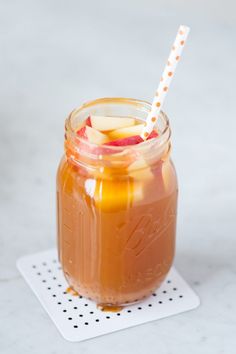 an apple cider in a mason jar with a straw